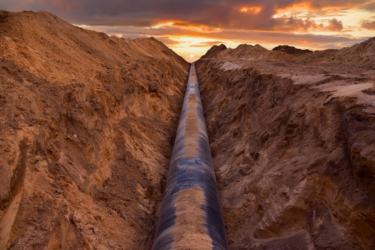 Natural gas pipeline trench in the ground at sunset